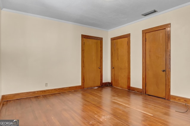 unfurnished bedroom featuring crown molding and light hardwood / wood-style floors