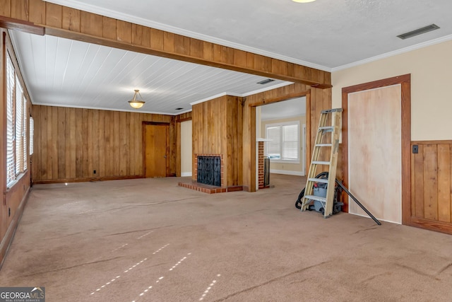 unfurnished living room with crown molding, wooden walls, and carpet flooring