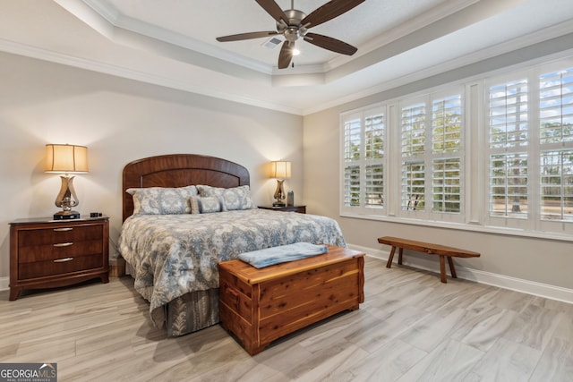 bedroom featuring crown molding, a tray ceiling, ceiling fan, and light wood-type flooring