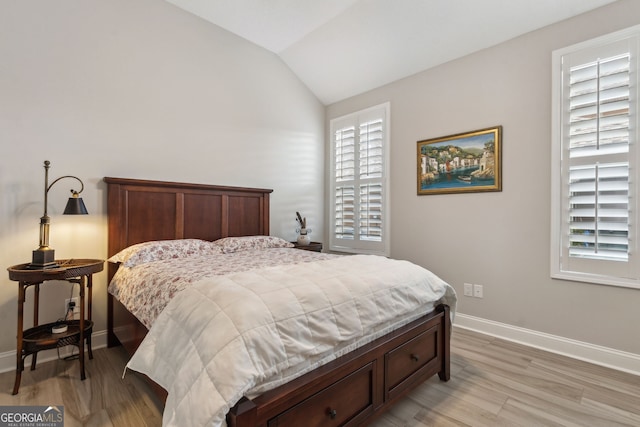 bedroom with lofted ceiling and light hardwood / wood-style floors