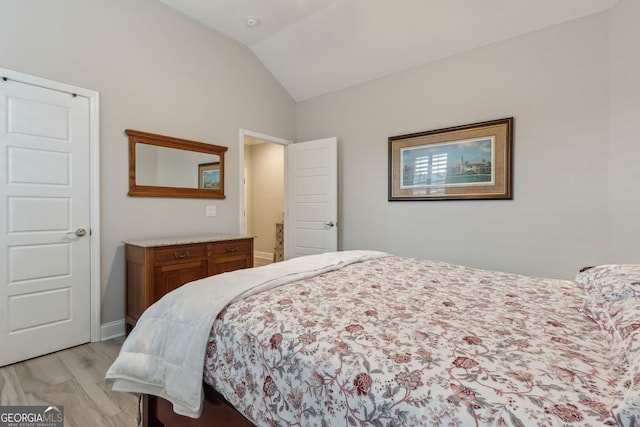 bedroom with lofted ceiling and light wood-type flooring