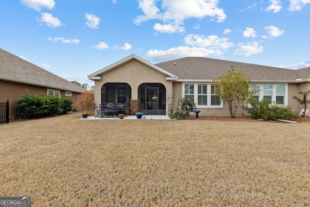 back of property with a patio, a sunroom, and a lawn