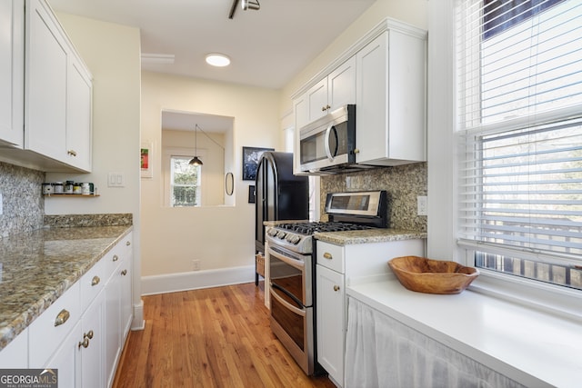 kitchen with white cabinetry, decorative backsplash, and stainless steel appliances