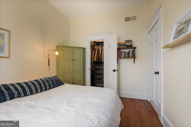 bedroom featuring a closet, a spacious closet, and dark hardwood / wood-style floors