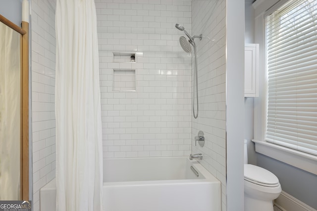 bathroom with shower / tub combo with curtain and toilet