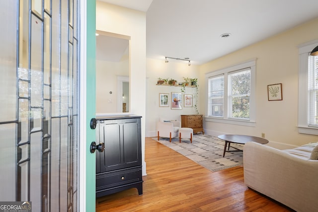 sitting room with track lighting and light hardwood / wood-style flooring