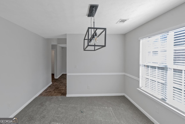 unfurnished dining area with dark colored carpet