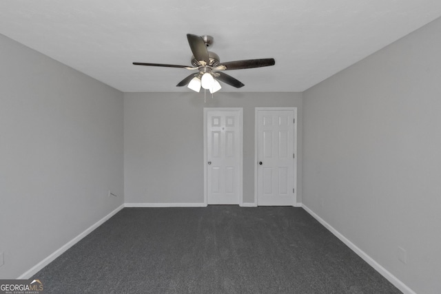 unfurnished bedroom with ceiling fan and dark carpet