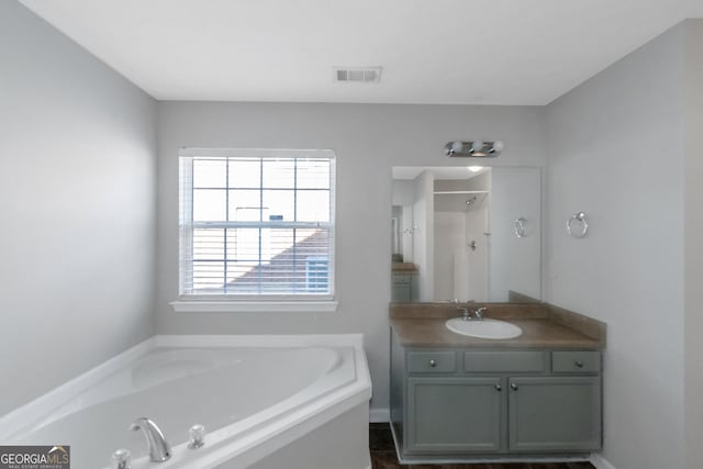 bathroom with vanity and shower with separate bathtub