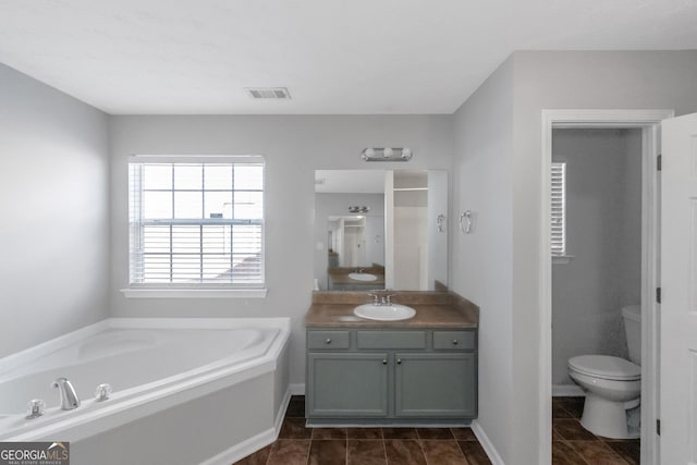 bathroom with vanity, toilet, tile patterned flooring, and a washtub