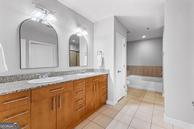 full bath with tile patterned flooring, double vanity, a garden tub, and a sink