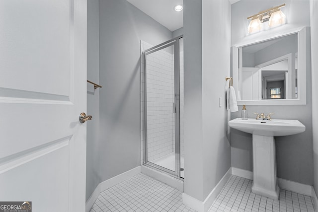 full bath with tile patterned flooring, a shower stall, and baseboards