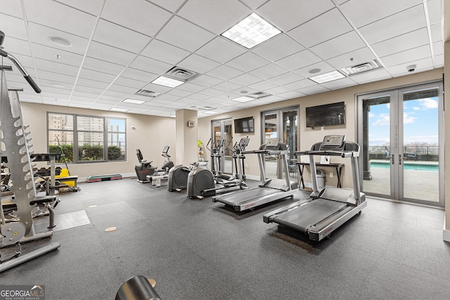 workout area featuring french doors, visible vents, a drop ceiling, and baseboards