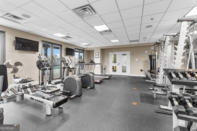 exercise room with visible vents, baseboards, and a drop ceiling