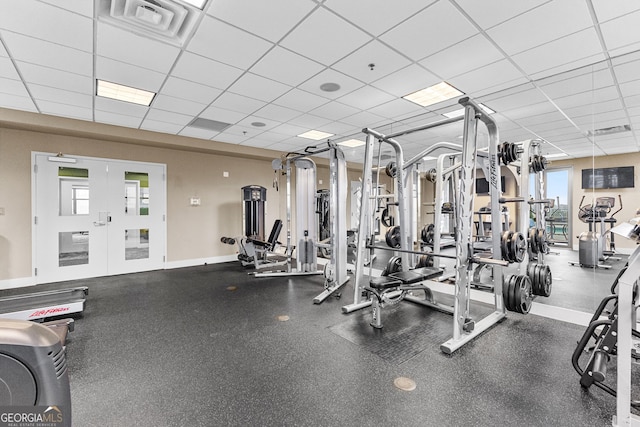 workout area with a drop ceiling, visible vents, baseboards, and french doors