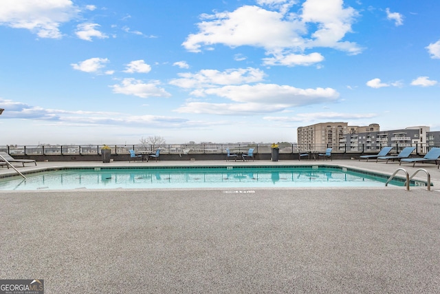 community pool featuring a patio and fence