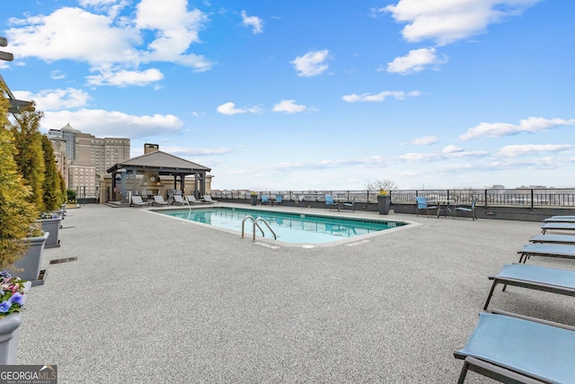 community pool with a gazebo, a patio, and fence