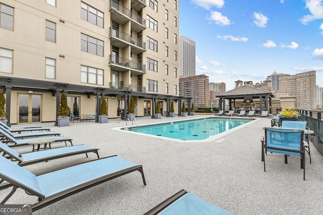 pool featuring a gazebo, french doors, a view of city, and a patio