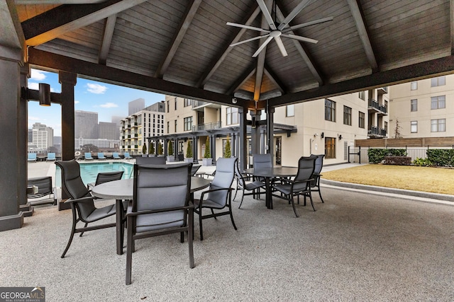 view of patio featuring a city view, outdoor dining space, a gazebo, a community pool, and ceiling fan