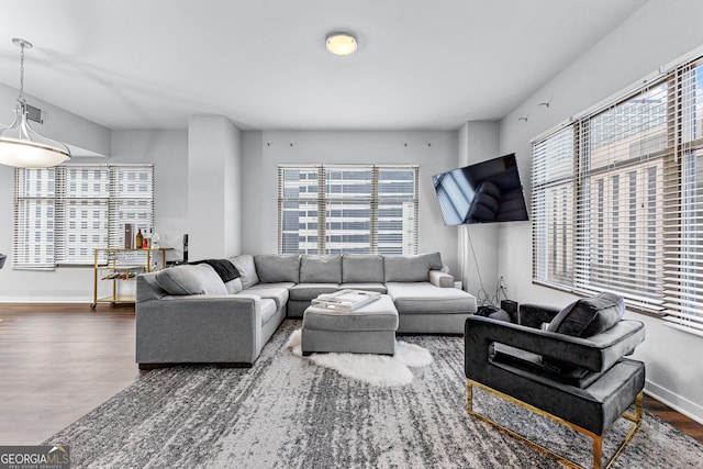 living room featuring visible vents, baseboards, and wood finished floors