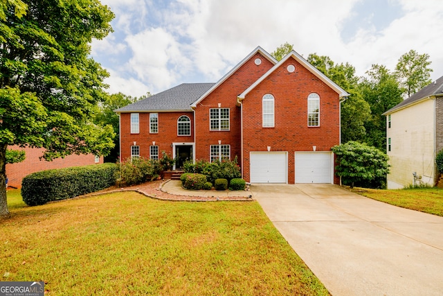 colonial house with a garage, driveway, brick siding, and a front lawn