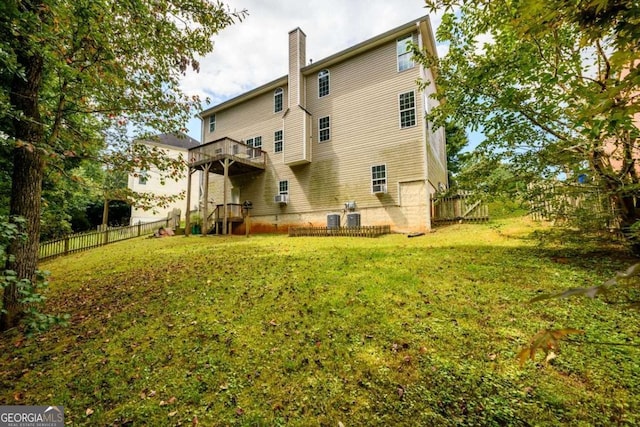 rear view of property with a chimney, fence, and a lawn