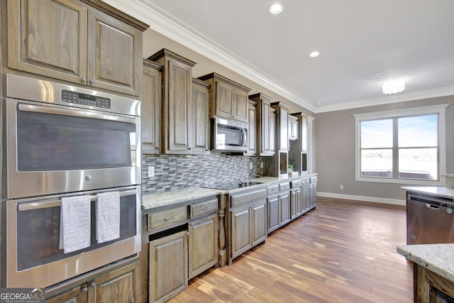 kitchen with tasteful backsplash, light stone counters, crown molding, and appliances with stainless steel finishes