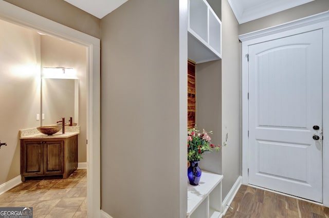 mudroom featuring crown molding, light hardwood / wood-style floors, and sink