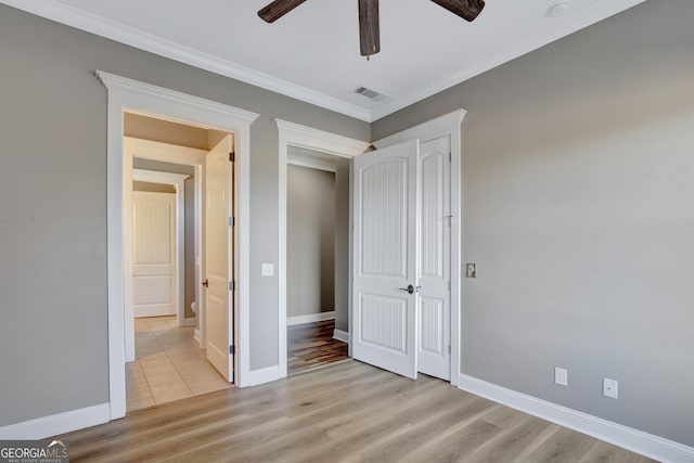 unfurnished bedroom with ornamental molding, ceiling fan, and light hardwood / wood-style flooring