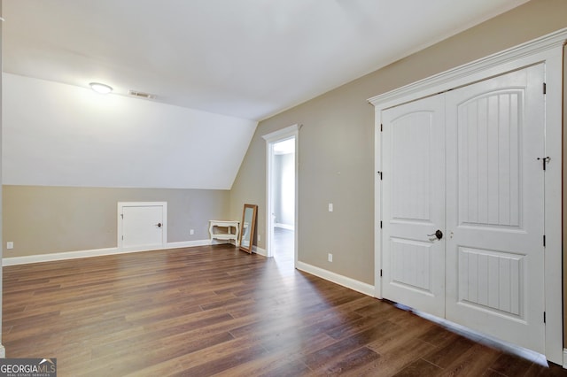 additional living space featuring lofted ceiling and dark hardwood / wood-style floors