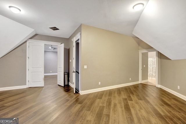 additional living space with lofted ceiling and hardwood / wood-style floors