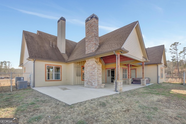 rear view of house featuring a yard, central AC, and a patio