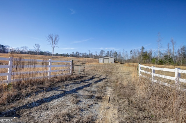 view of yard with a storage shed and a rural view