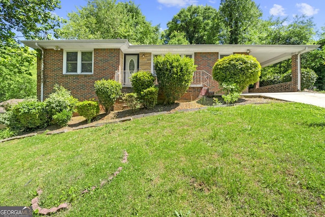 view of front of house featuring brick siding, driveway, and a front lawn