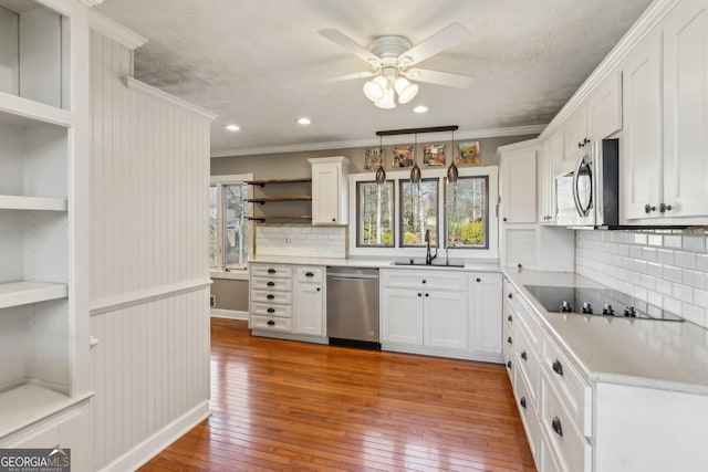 kitchen featuring sink, white cabinetry, crown molding, light wood-type flooring, and appliances with stainless steel finishes