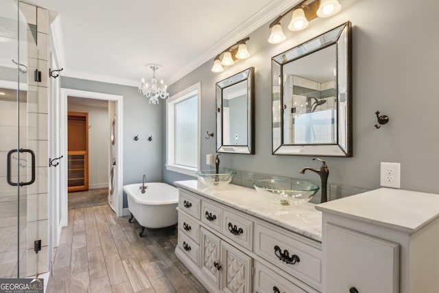 bathroom featuring an inviting chandelier, ornamental molding, shower with separate bathtub, and vanity