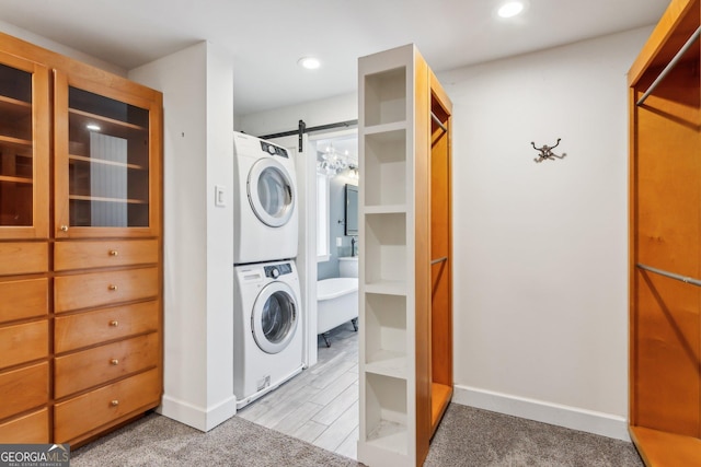 laundry room featuring a barn door and stacked washing maching and dryer