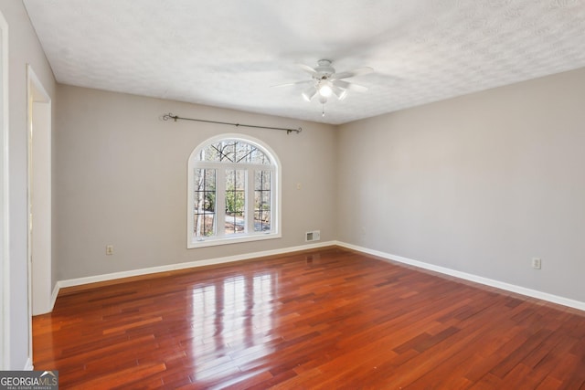 empty room featuring wood-type flooring, ceiling fan, and a textured ceiling