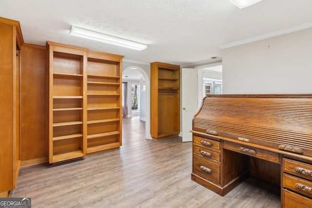 unfurnished office featuring ornamental molding, a textured ceiling, and light hardwood / wood-style flooring