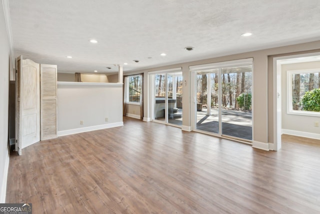 unfurnished living room featuring wood-type flooring and a textured ceiling