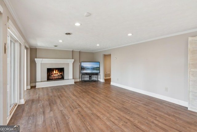 213 Pine Crest Dr, Cumming, GA 30040 - unfurnished living room with recessed lighting, wood finished floors, a warm lit fireplace, and crown molding