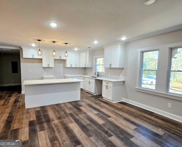 kitchen with white cabinetry, decorative light fixtures, dark hardwood / wood-style flooring, and a kitchen island