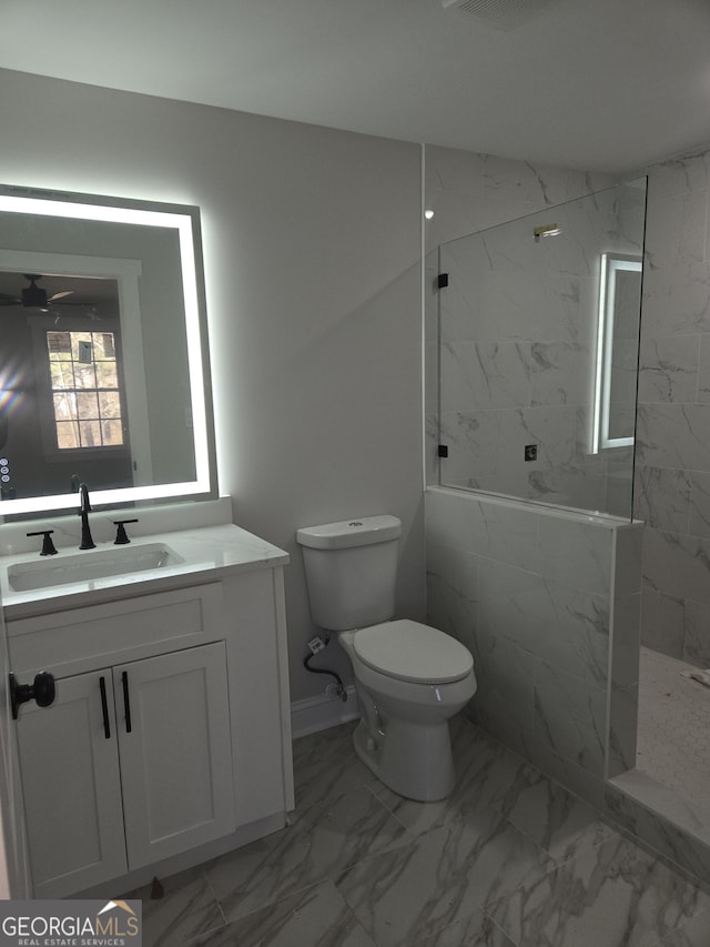 bathroom with vanity, toilet, and tiled shower