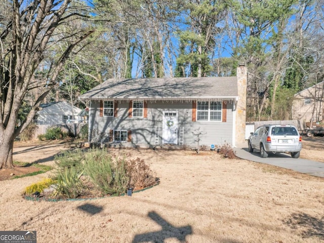 view of front of home featuring driveway and a chimney