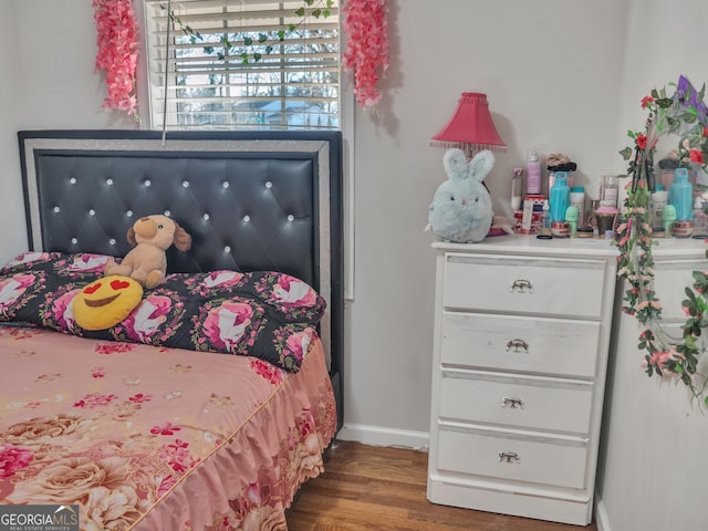 bedroom featuring wood finished floors and baseboards