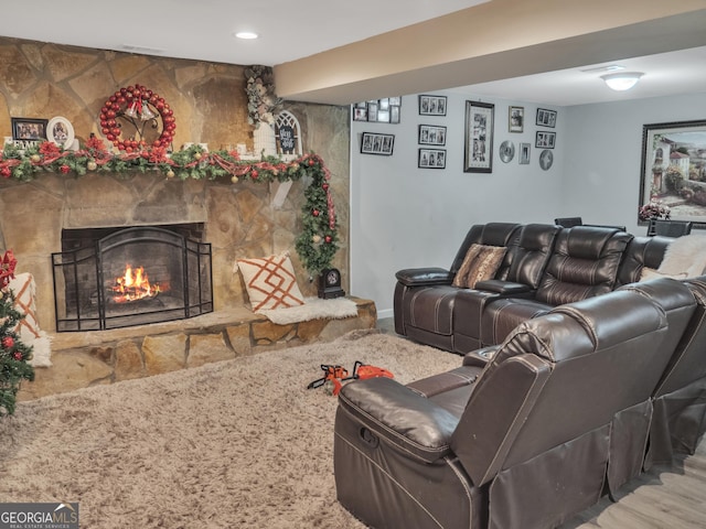 living area featuring a stone fireplace and visible vents