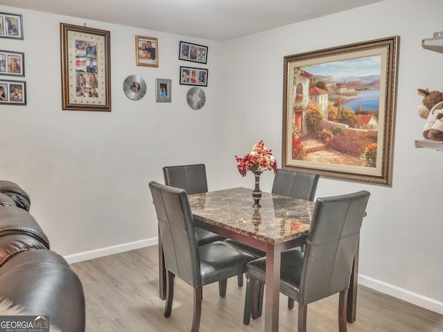 dining area with light wood-style floors and baseboards