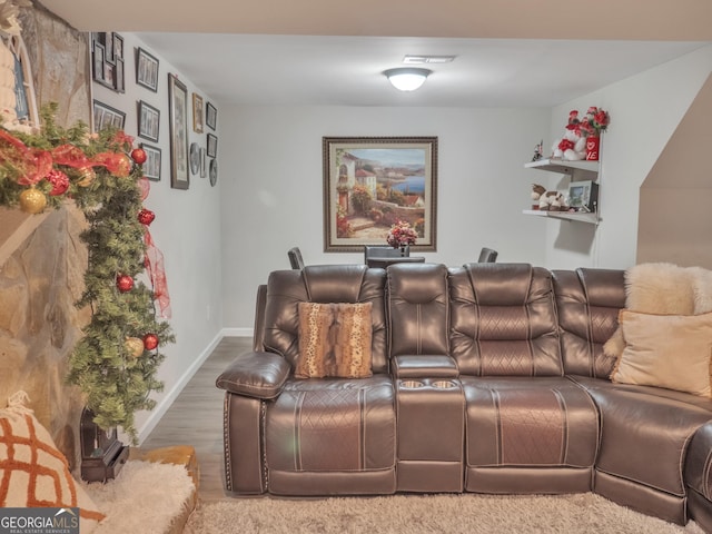 home theater room with visible vents, baseboards, and wood finished floors