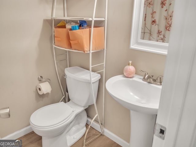 bathroom featuring wood finished floors, toilet, and baseboards