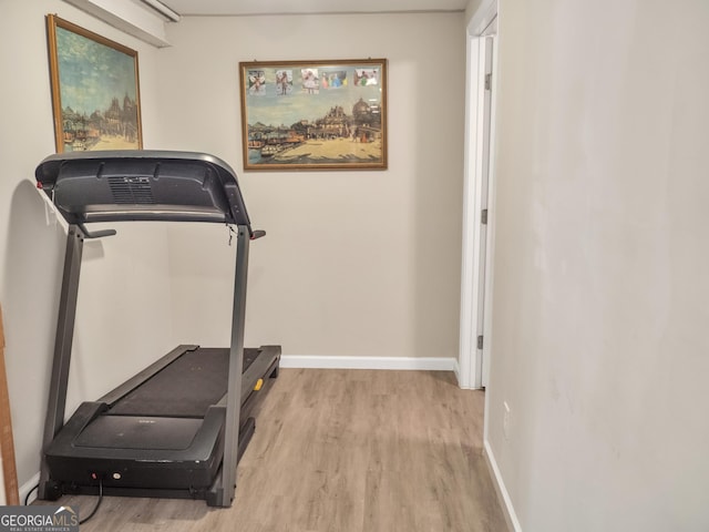 workout area with baseboards and wood finished floors